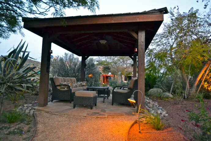 Solid-roof timber patio cover with exposed rafters over a seating area