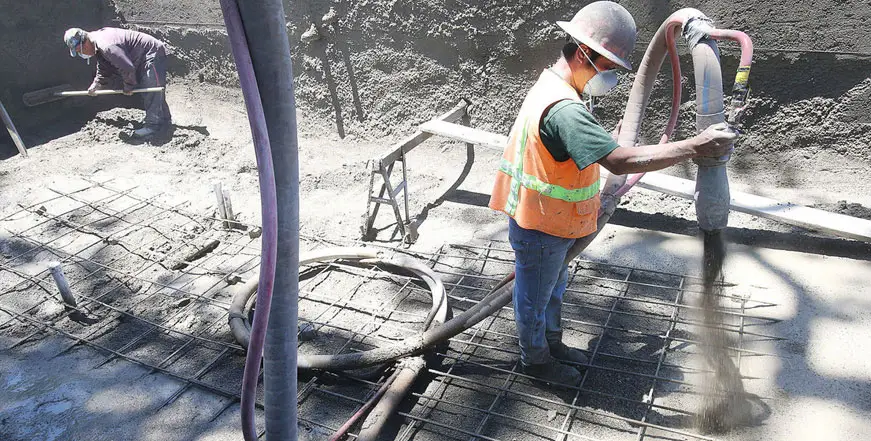 Crew shooting concrete onto a steel-reinforced pool shell