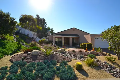 Low-water front yard of succulents, agave and boulders in decomposed granite