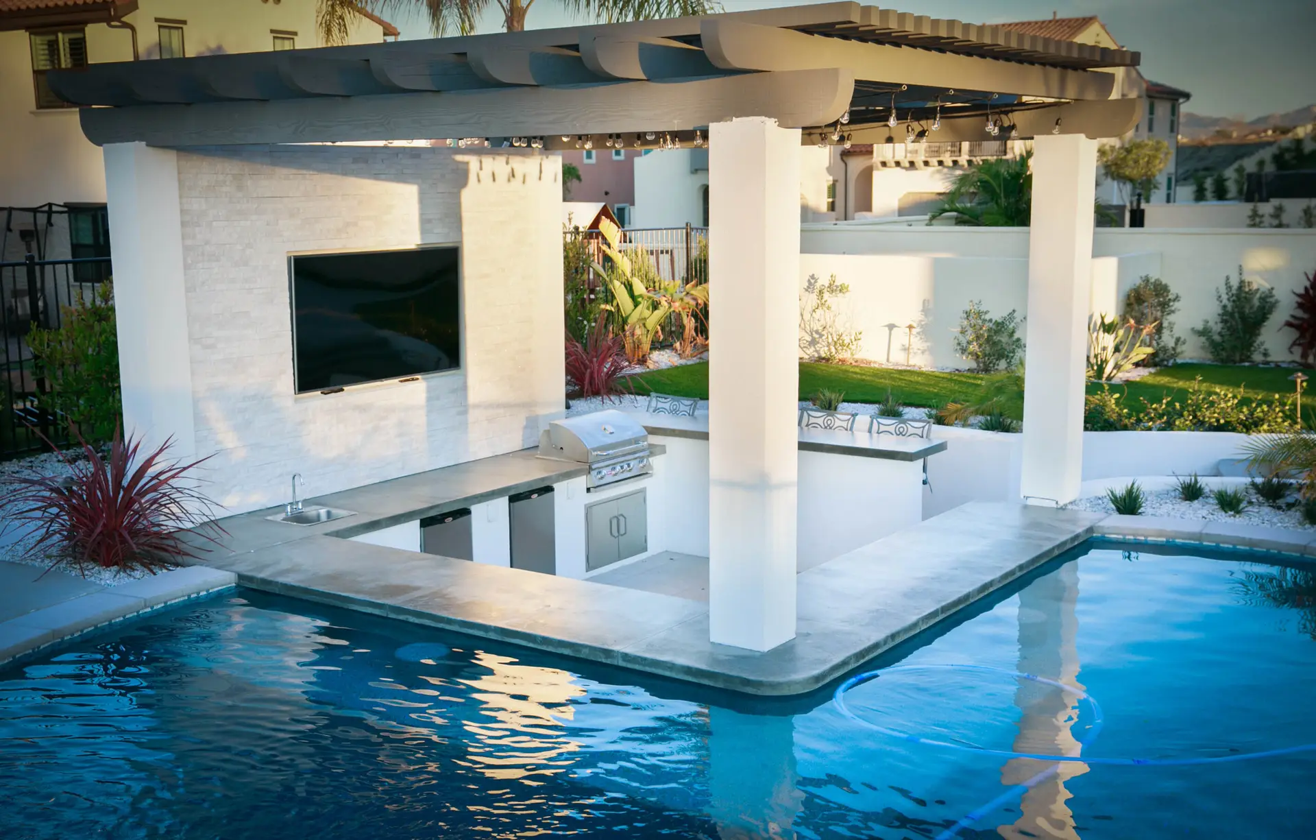 An outdoor kitchen, pool and covered structure completed by California Smartscape